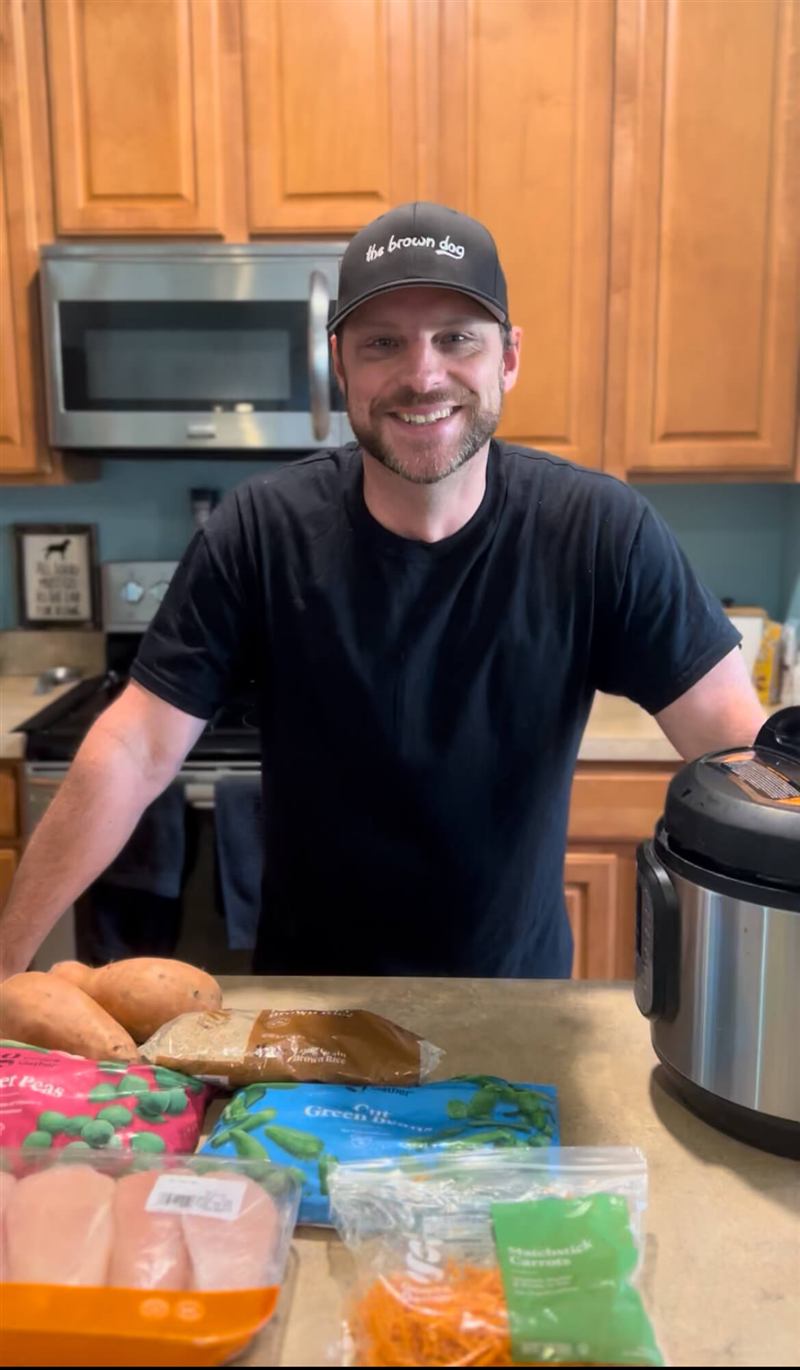 Hutch in the kitchen with a pressure cooker and prepped ingredients, mid-batch of homemade dog food.